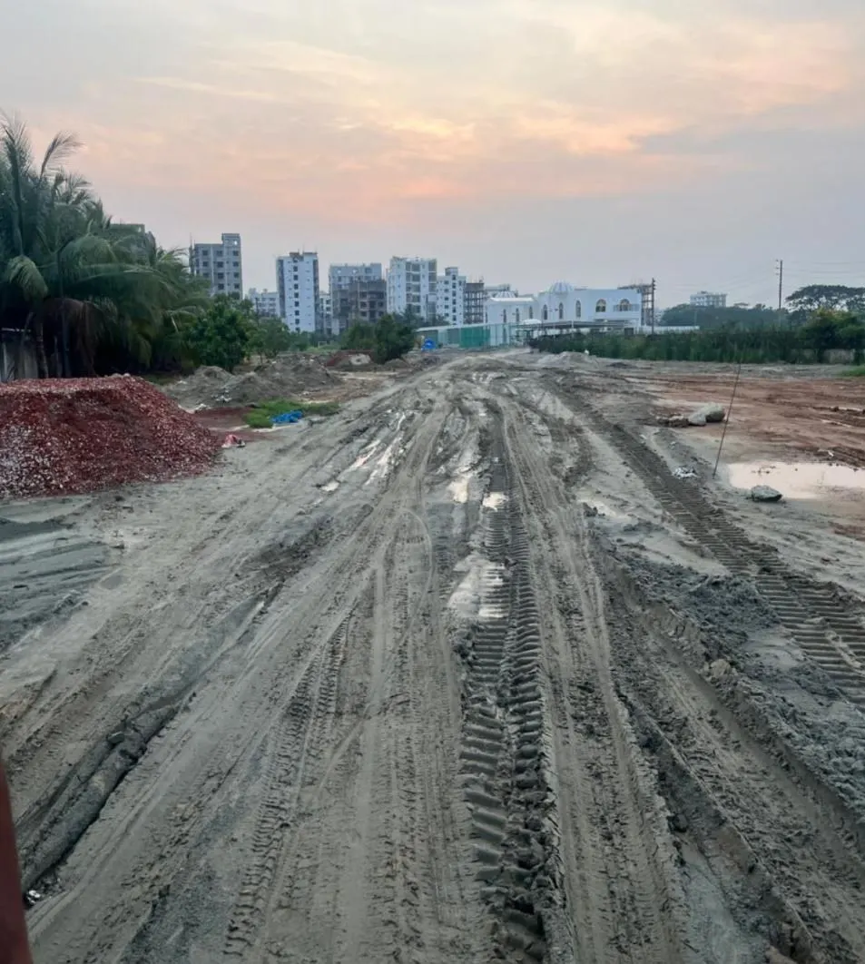 Chairman Bungalow Road before treatment — churned sand and soil, rutted by plant tracks and standing water.