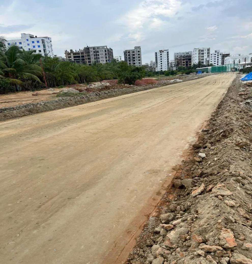 A wide, freshly finished SoilBinder-stabilized road base at Priyanka Runway City, Dhaka, running toward the horizon under an open sky.