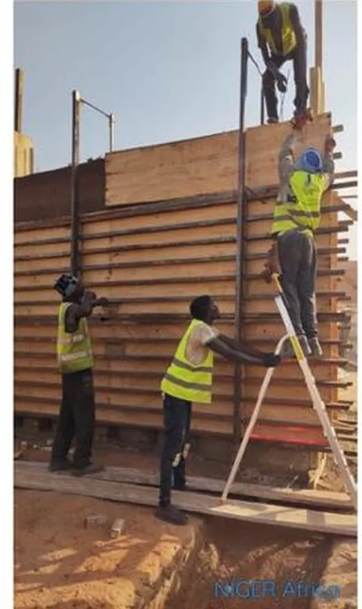 Stamped-earth walls rising inside modern formwork.